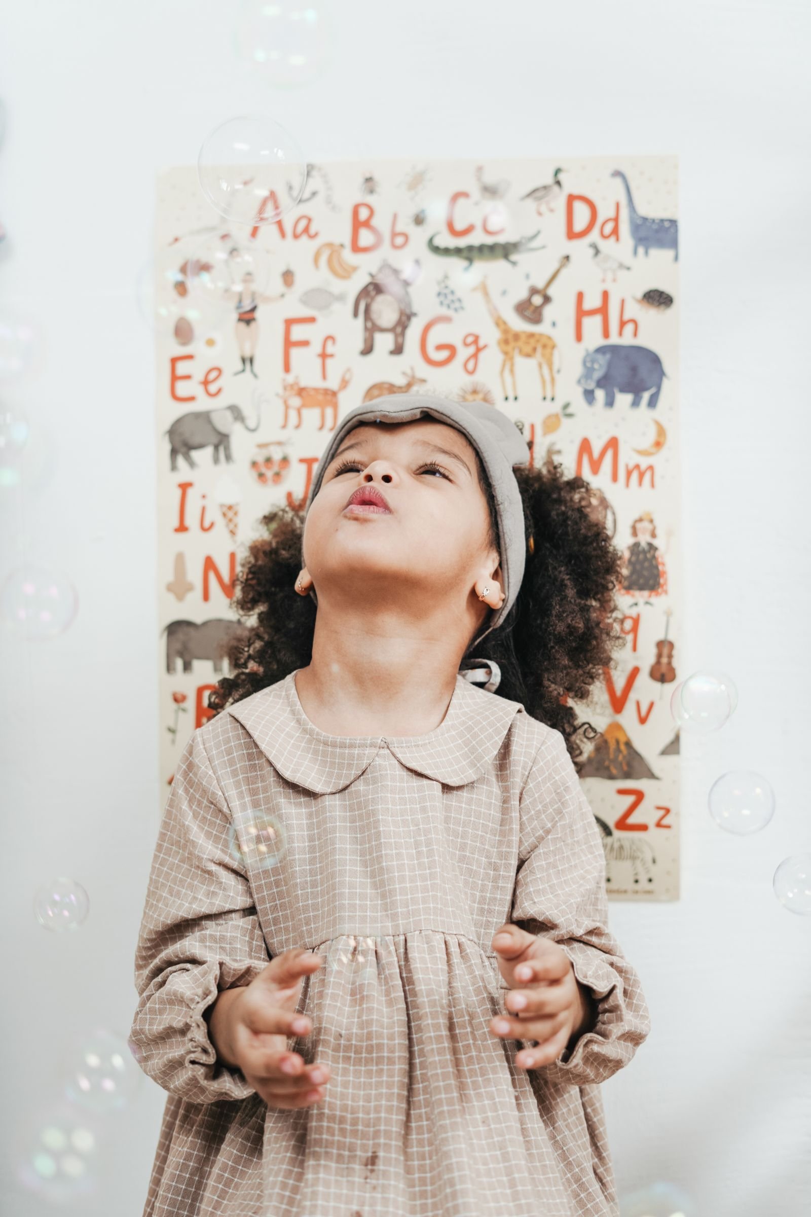 Girl blowing bubbles indoors