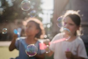 Children playing outdoors with bubbles