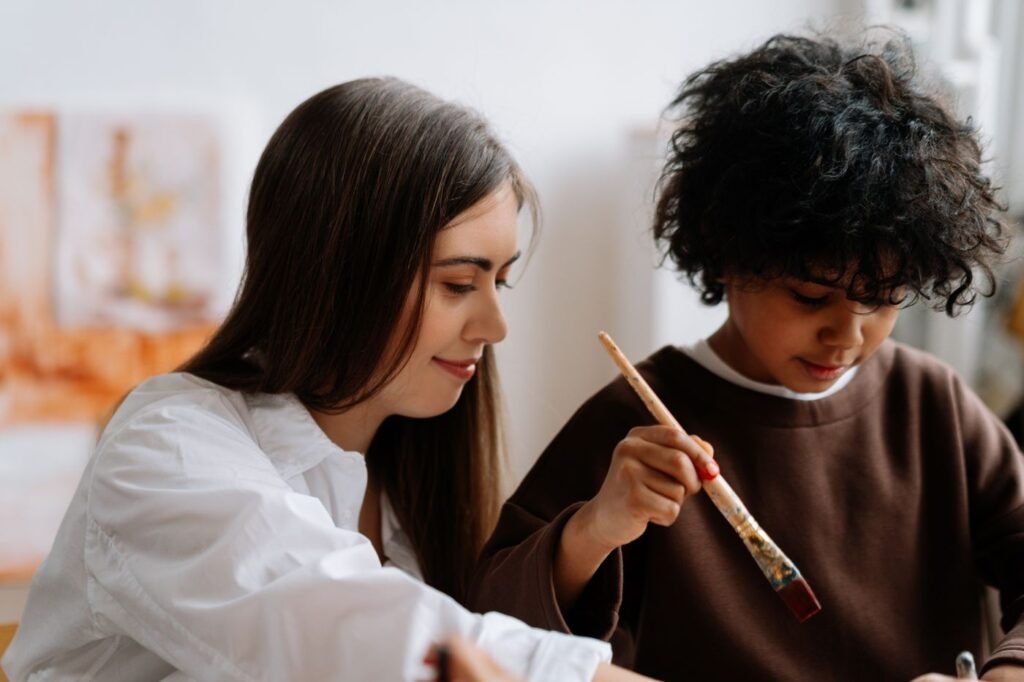 Teacher guiding a child's painting activity